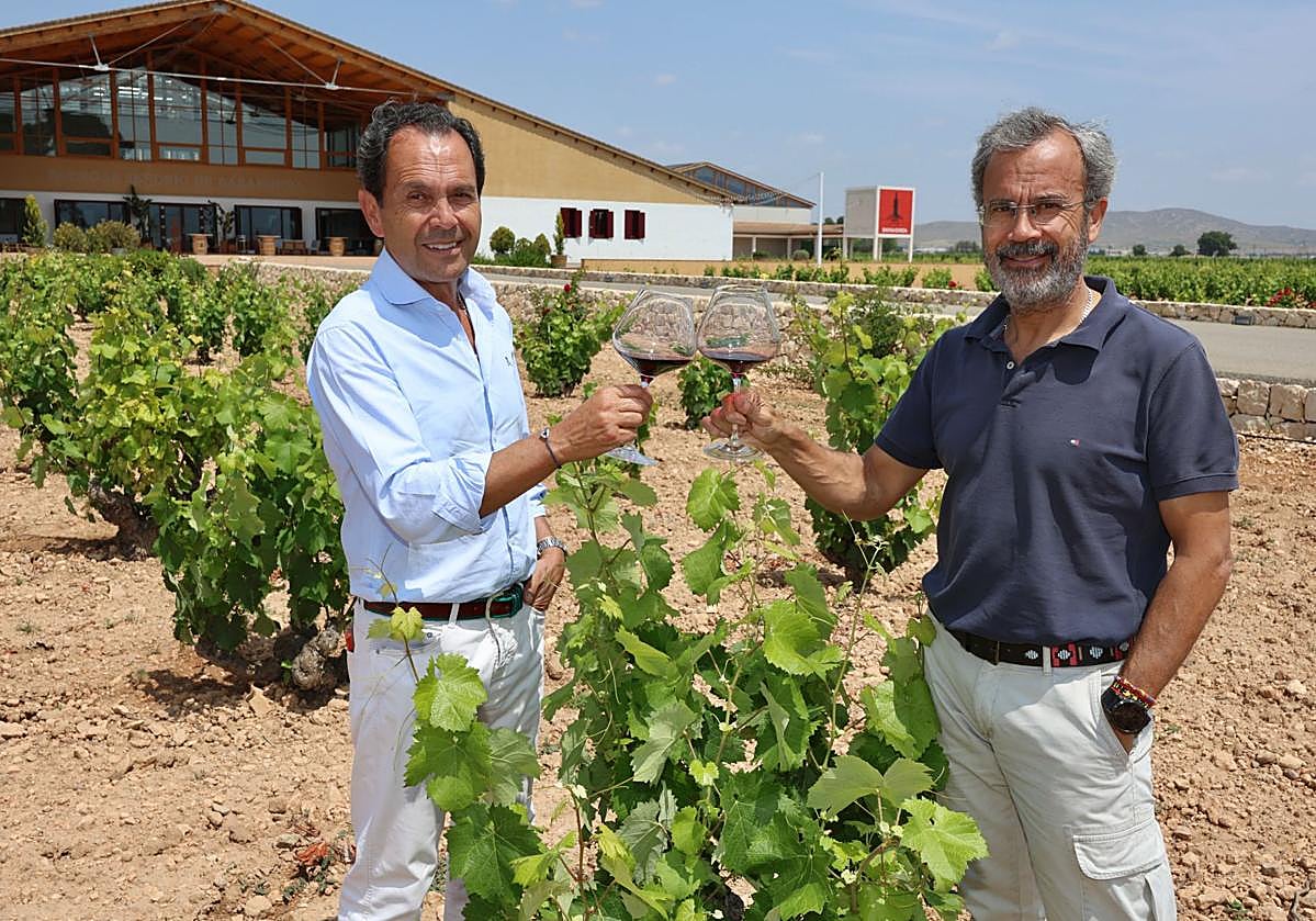 Los hermanos Antonio y Alfredo Candela brindan con el vino conmemorativo del centenario en una de las parcelas de la bodega.