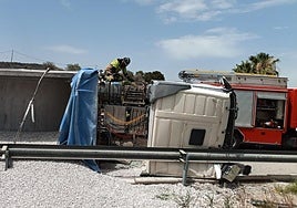 Un bombero trata de rescatar al conductor atrapado.