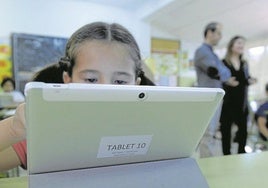Una niña en clase con una tableta, en una fotografía de archivo.