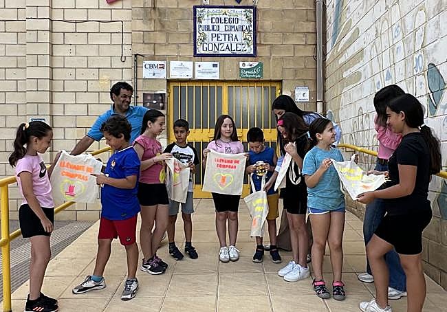 Alumnos del CEIP Petra González muestran las bolsas que hicieron.