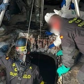 Un agente de la Guardia Civil se introduce en el depósito de aceite donde se encontraron los restos humanos.