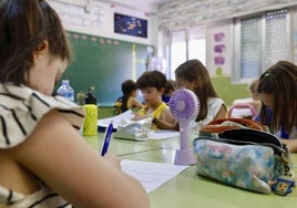 Alumnos en el colegio Luis Costa tratan de mitigar el calor con mini ventiladores y agua.