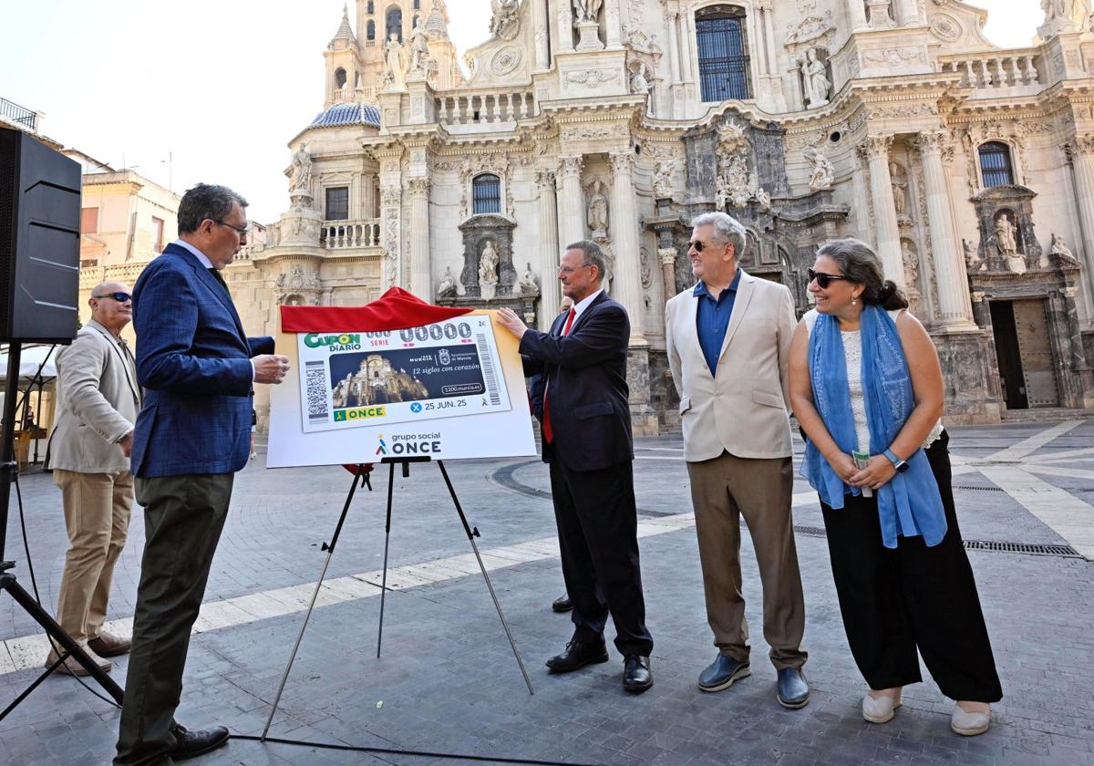El alcalde de Murcia, José Ballesta, y el director general adjunto de la ONCE, Patricio Cárceles, destapan el décimo con la imagen de la Catedral en la plaza del Cardenal Belluga.