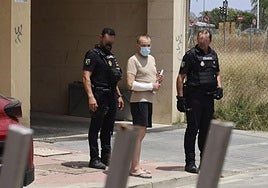 El detenido custodiado por dos agentes, tras el registro de su casa en Churra, ayer.