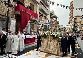 La carroza del Corpus Christi pasa junto a uno de los altares instalados en las calles.