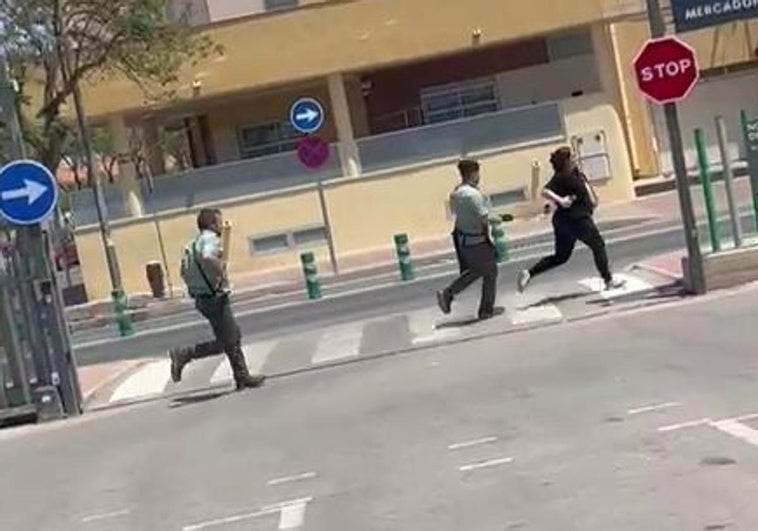 Dos trabajadores persiguen a una sospechosa de robar cinco botellas de whisky en un supermercado de Torre Pacheco.