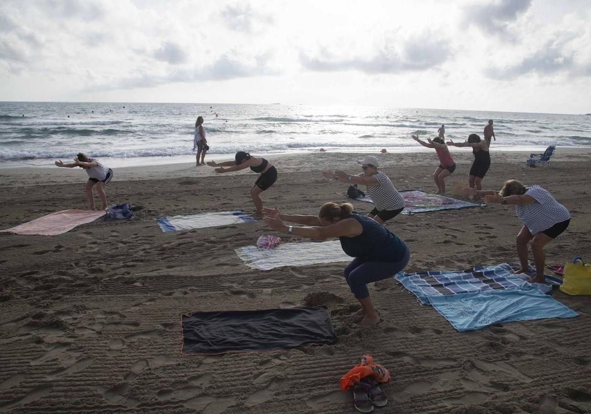 Imagen de archivo de unas mujeres practicando yoga en la playa.