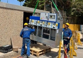 Tres operarios de la compañía eléctrica trabajan en la instalación de un centro de transformación en La Manga.