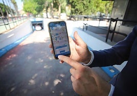 Un móvil muestra la nueva aplicación de pago de los servicios de movilidad, frente a la entrada del parking de Verónicas.