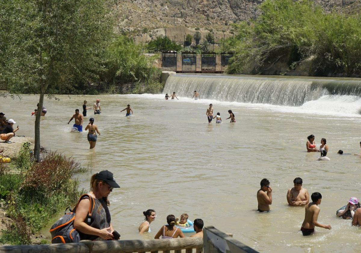 Vecinos y turistas en El Jarral de Abarán, con el tobogán natural al fondo, su principal reclamo.