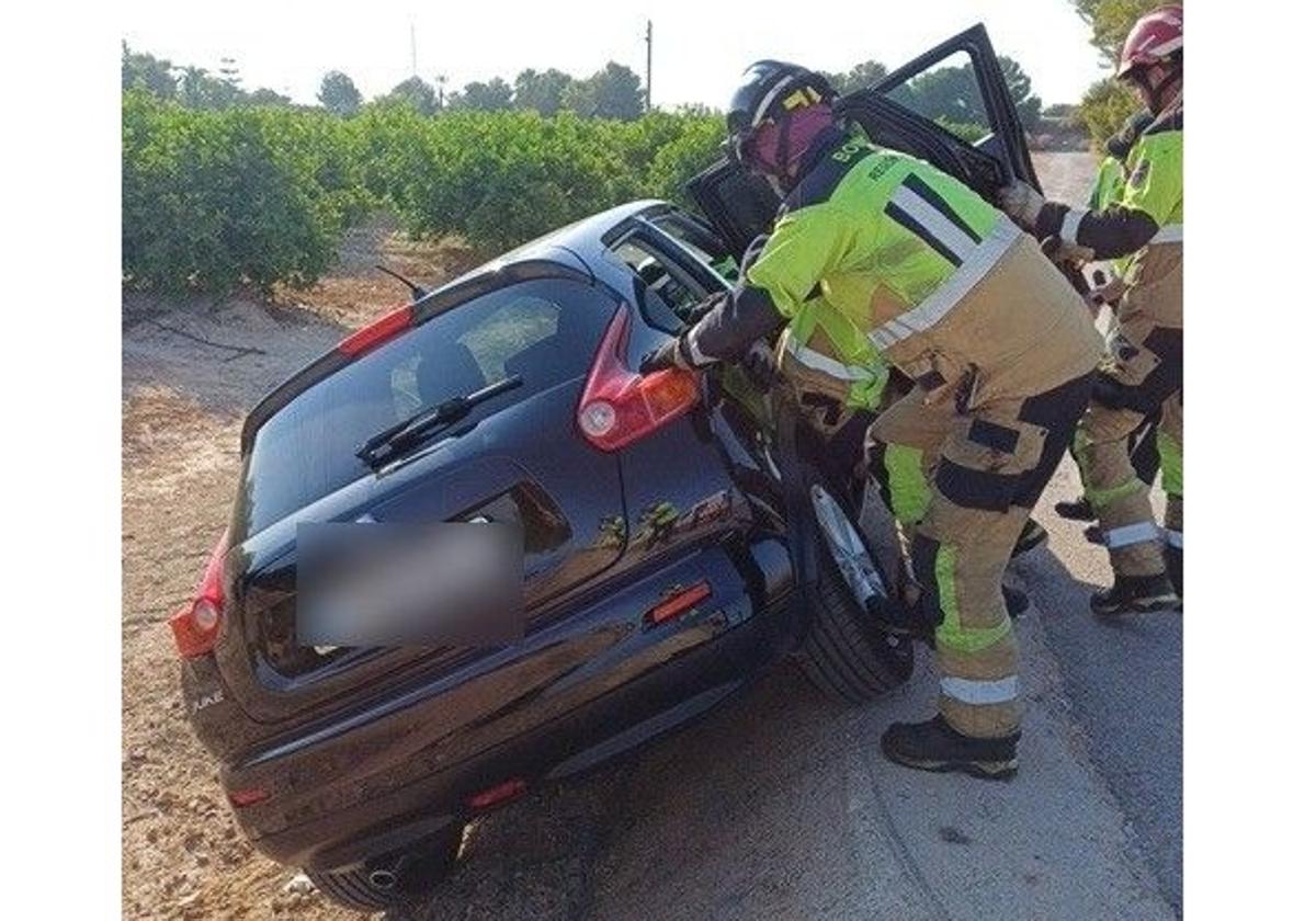 Los bomberos rescatando a los ocupantes del vehículo.