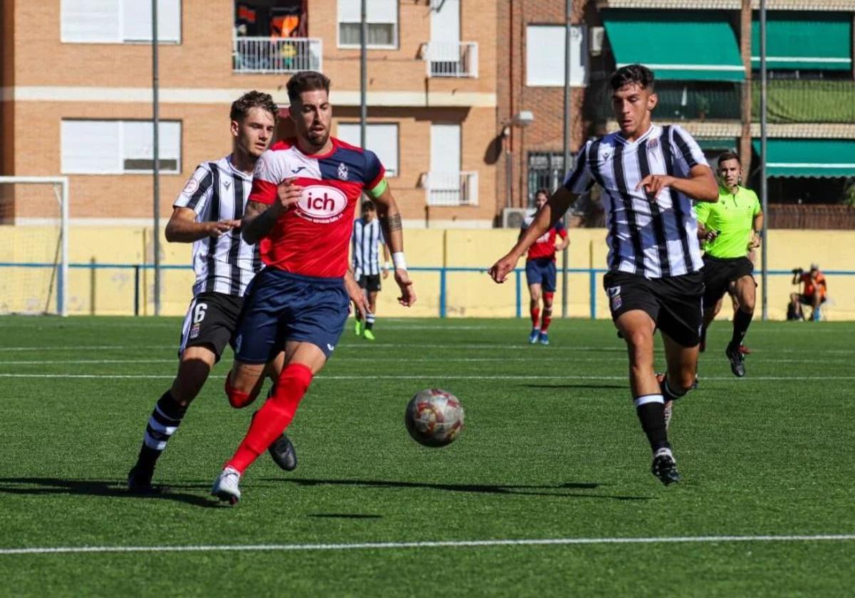 Dos futbolistas del Cartagena B presionan a un jugador de El Palmar, en una imagen de archivo.