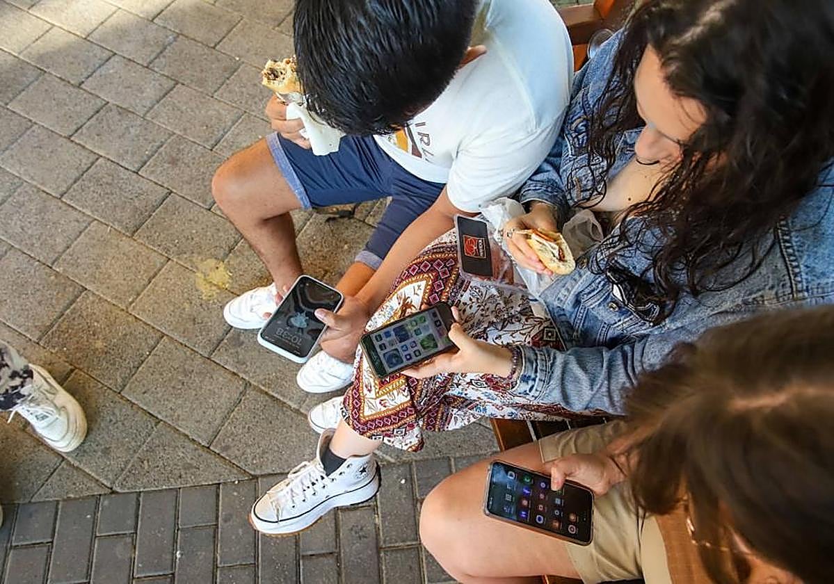 Un grupo de jóvenes manejando sus teléfonos móviles durante el descanso en un instituto de Murcia.