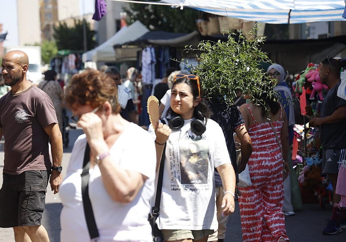 Clientes del tradicional mercado del Cénit deambulan entre los puestos mientras en la calle caía un sol de justicia.