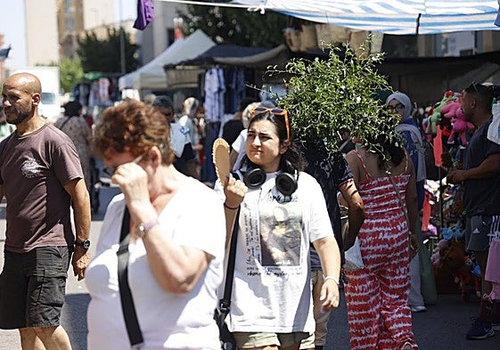 Clientes del tradicional mercado del Cénit deambulan entre los puestos mientras en la calle caía un sol de justicia.