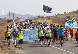 Vecinos de Los Nietos, este domingo, cortan la RM-F54 durante la marcha reivindicativa con pancartas.
