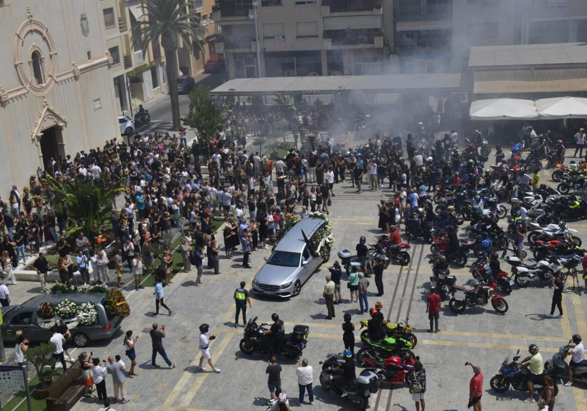 Decenas de vecinos y aficionados al motociclismo acompañan al coche fúnebre, este martes, en San Javier.