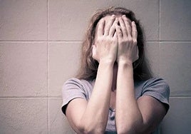 Una mujer con las manos en la cara.