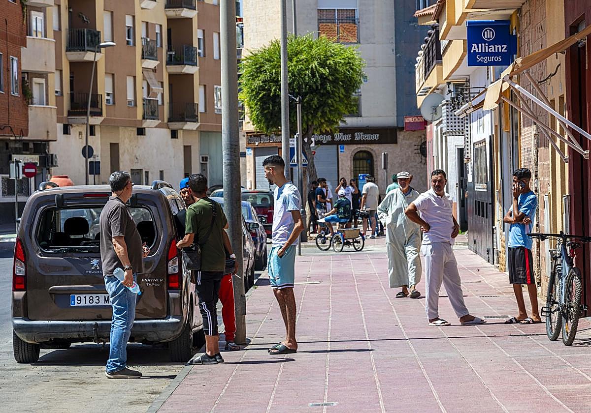 Varios vecinos de origen marroquí en Torre Pacheco, junto a una furgoneta vandalizada tras los disturbios de los últimos dos días.