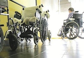 Una mujer en silla de ruedas en una residencia.