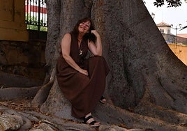 La actriz Inmaculada Rufete, sonriente, acomodada en uno de los árboles más longevos del Malecón, en Murcia.