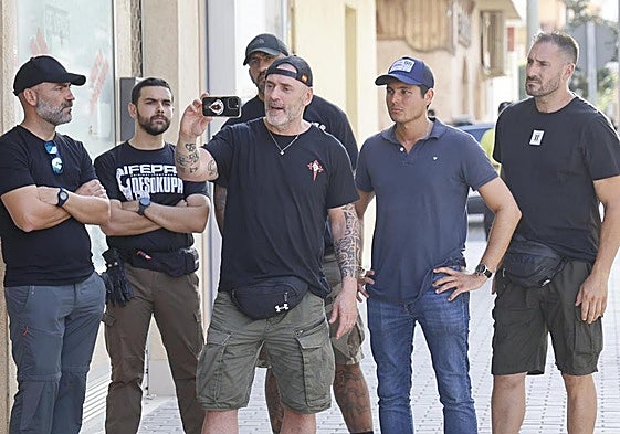 Dani Esteve, sujetando su teléfono móvil, y sus acompañantes, a su llegada a Torre Pacheco.