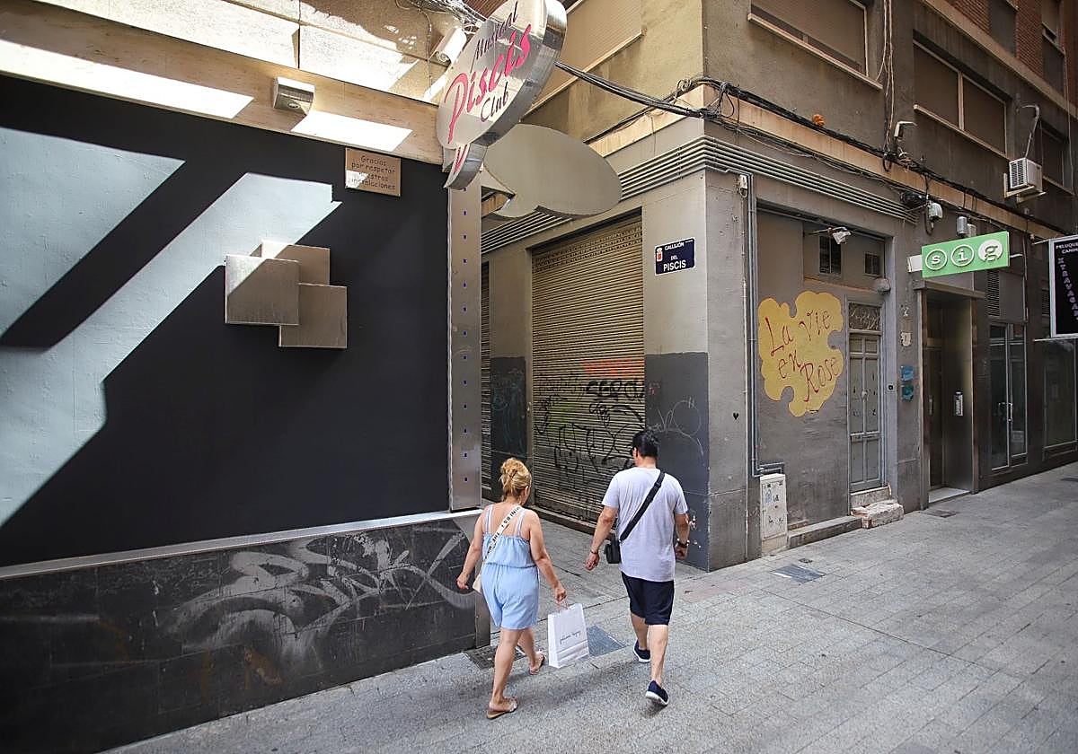 Dos viandantes, junto al callejón del Piscis en Murcia.