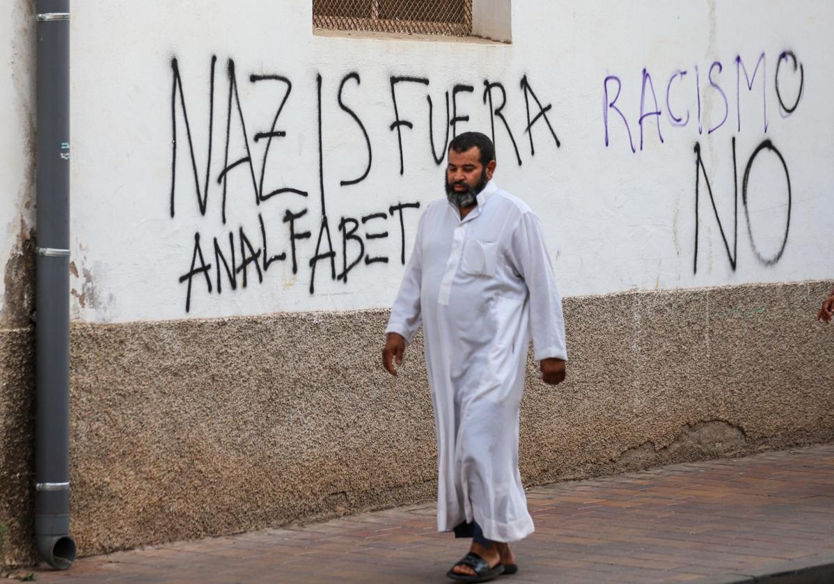 Un vecino con vestimenta árabe pasea por Torre Pacheco entre pintadas de rechazo hacia el racismo.