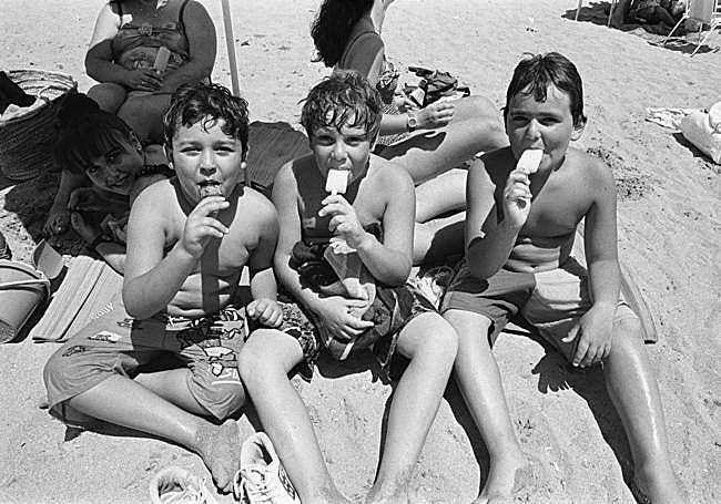 Tentempié. Tres niños, disfrutando de un polo a la orilla del mar (años 80).