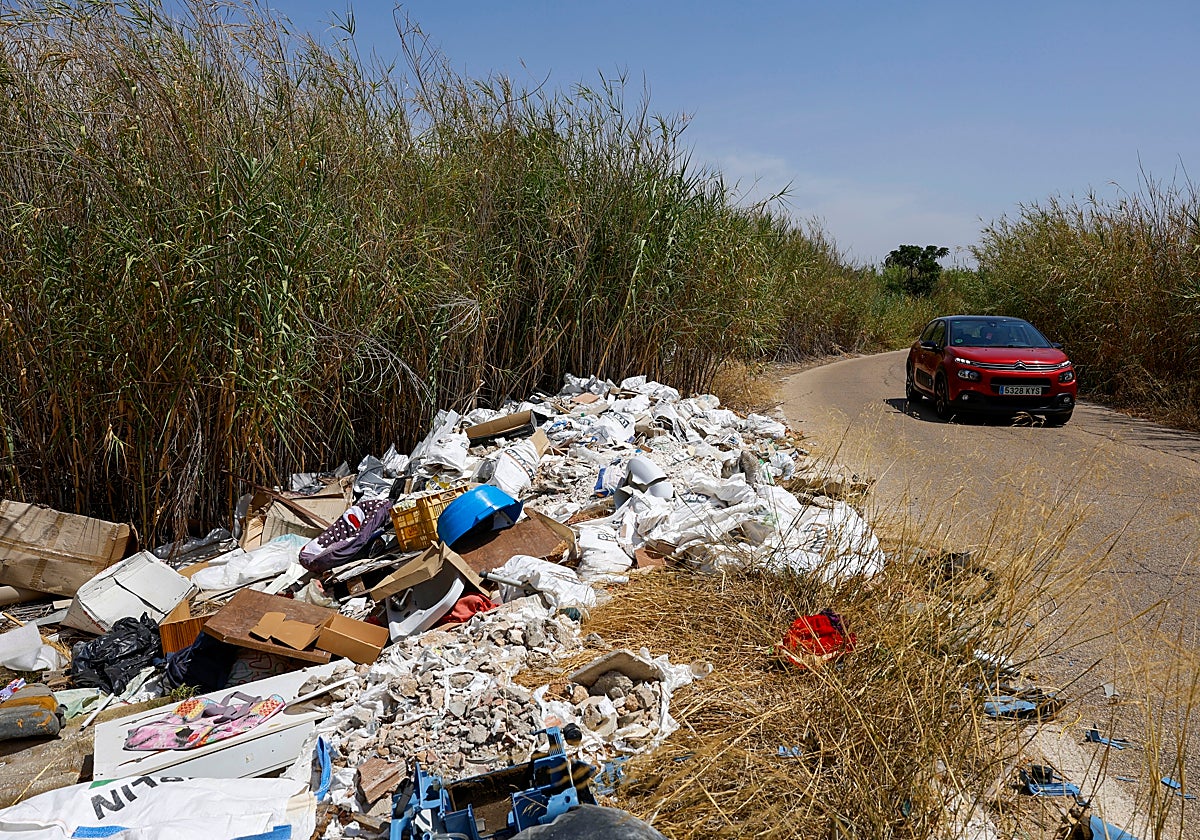 Escombros y otros desechos en el camino de servicio de la acequia Churra la Vieja, en El Puntal.
