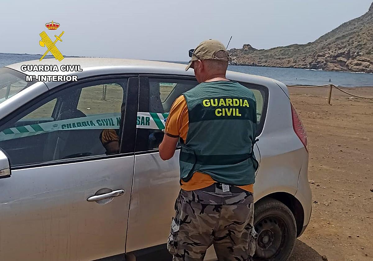 Un agente precinta uno de los vehículos en los que se transportaba a los inmigrantes una vez desembarcados.