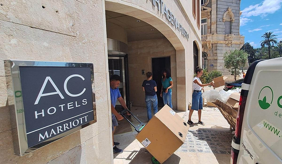 Un grupo de trabajadoras charla distendidamente entre el movimiento de obreros y repartidores a la entrada del hotel por la calle Real.