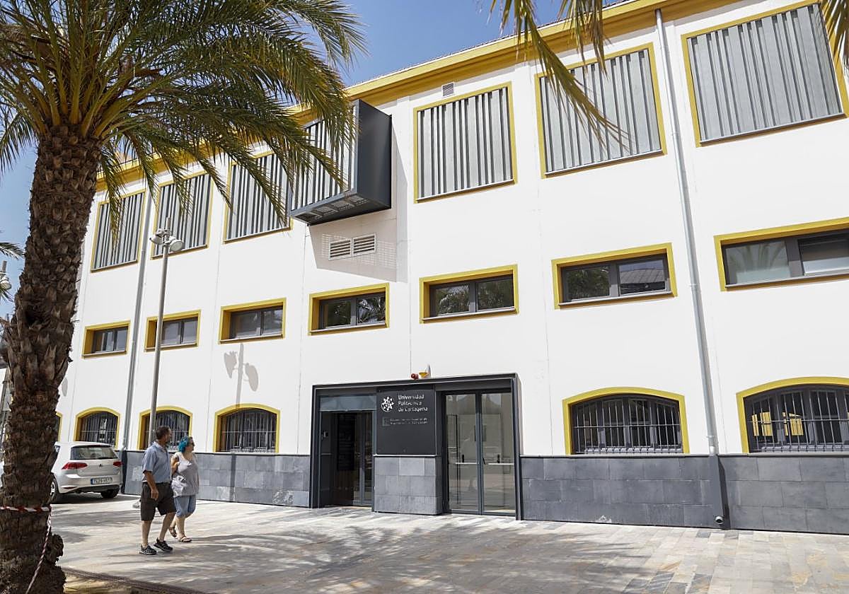 Dos personas pasean por la plaza del CIM, frente al rehabilitado edificio del Pañol, hoy ocupado por la UPCT.