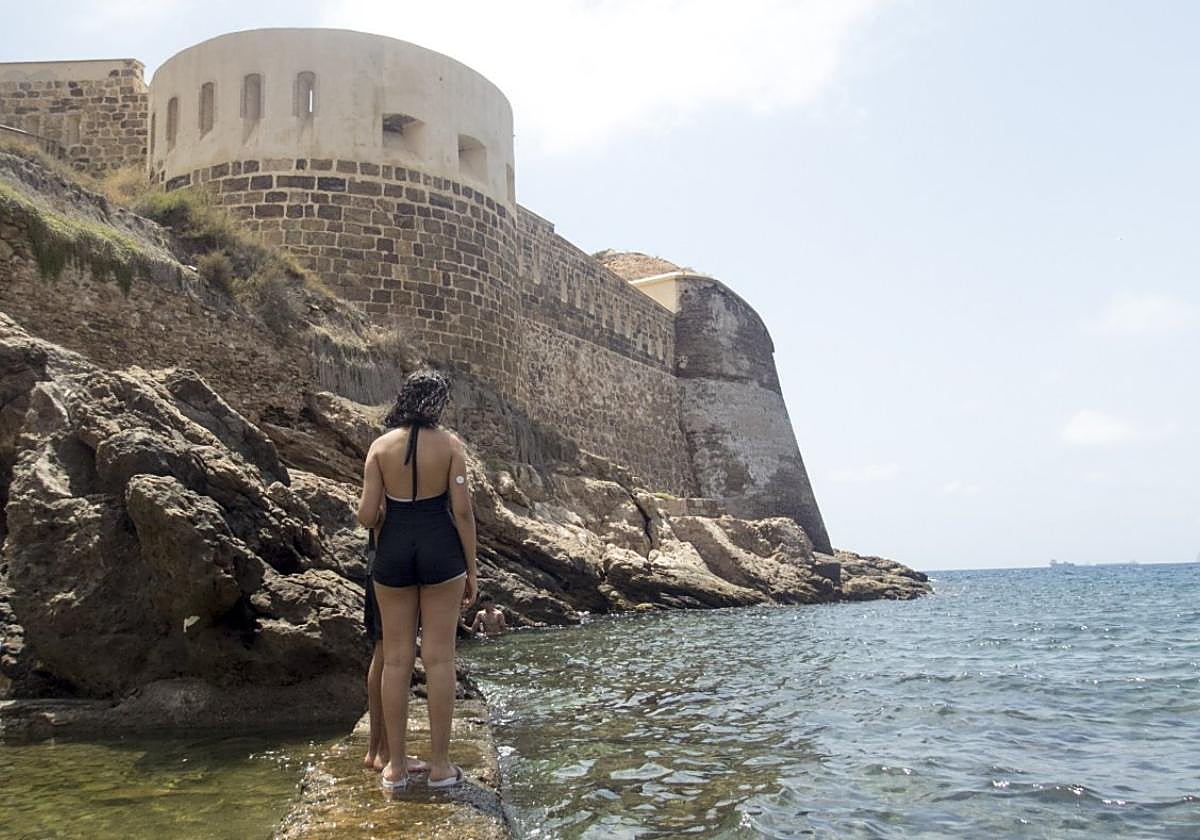 Dos cartageneros disfrutan de un refrescante baño entre las calas, junto a las baterías de Santa Florentina y Santa Ana Acasamatada, en plena bahía portuaria.