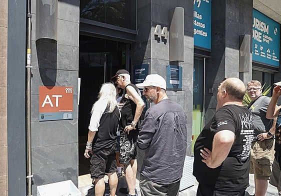 Un grupo de turistas espera para entrar en unos apartamentos turísticos de Cartagena.