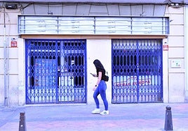 Una mujer pasa por delante del restaurante clausurado.