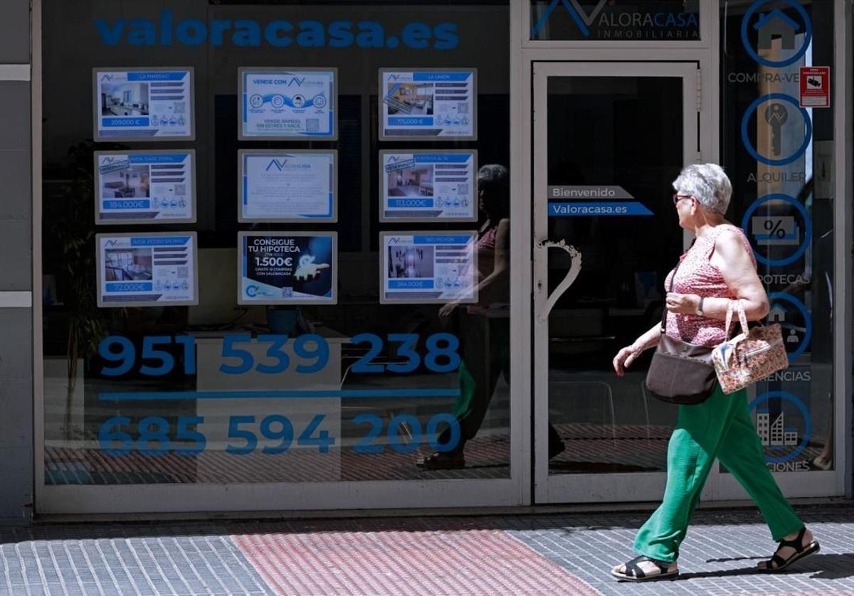 Una mujer frente a una inmobiliaria, en una foto de archivo.