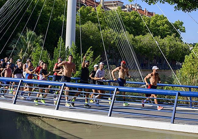 Pitufollow lidera a un grupo de corredores al paso por la pasarela del Malecón.