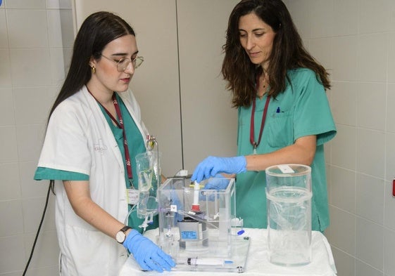Ana Cristina Hernández (derecha) y Gloria Martínez preparan esta semana el fármaco, que llega hasta la sala de Radiología intervencionista protegido en un cubo de metacrilato.