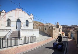 Lancinha, un migrante africano, pasa junto al Centro Social Ermita del Tercer Distrito y la mezquita Al-Nur (al fondo), este jueves, en Jumilla.