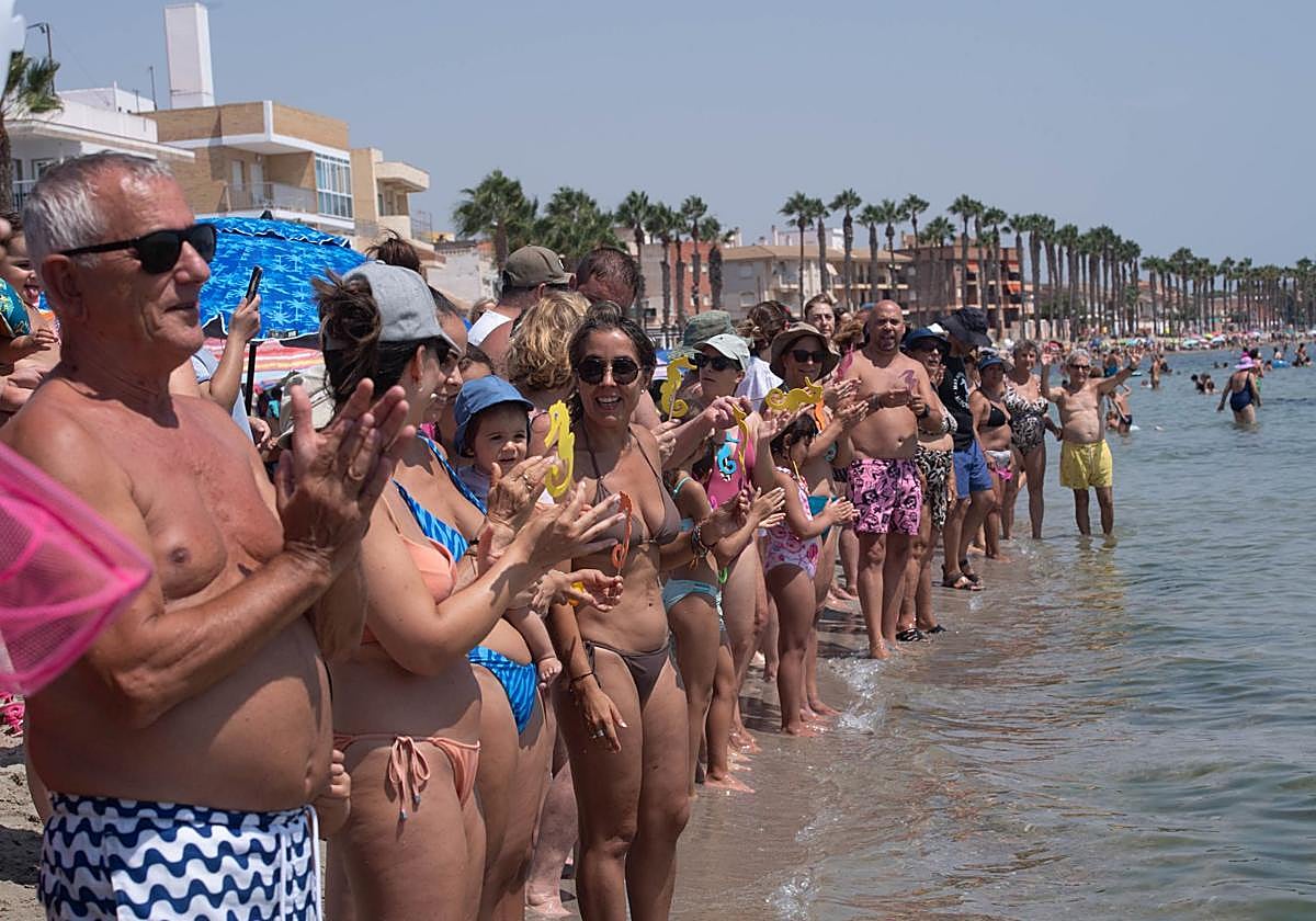 Una multitud de bañistas forman una cadena humana en Los Alcázares este sábado.