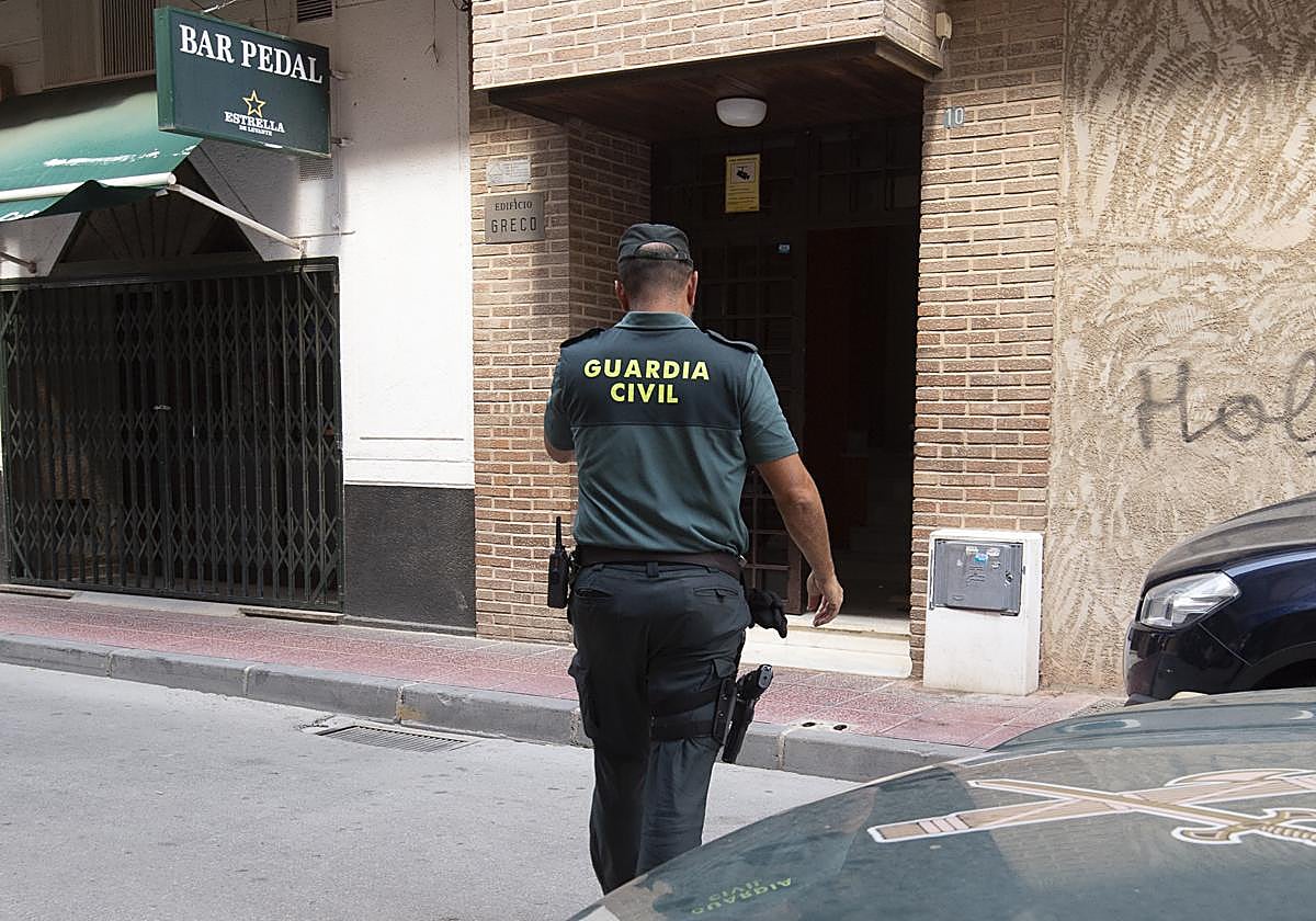 Un agente de la Guardia Civil, en la entrada del edificio de Cabezo de Torres donde fue hallado el cadáver.