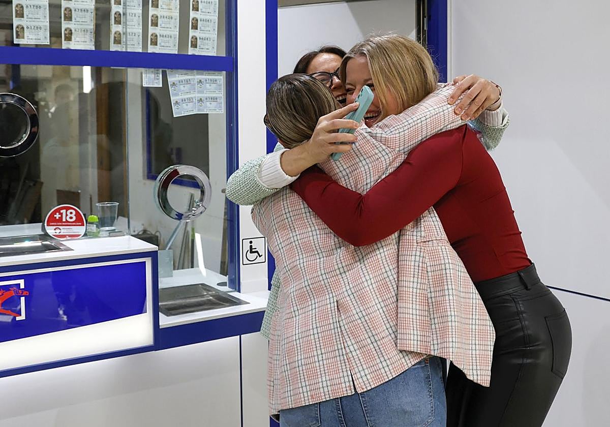 Tres mujeres se abrazan celebrando un premio de la Lotería de Navidad.