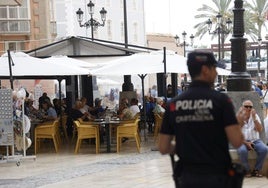 Un agente vigila una zona de terrazas llenas de clientes en Cartagena.