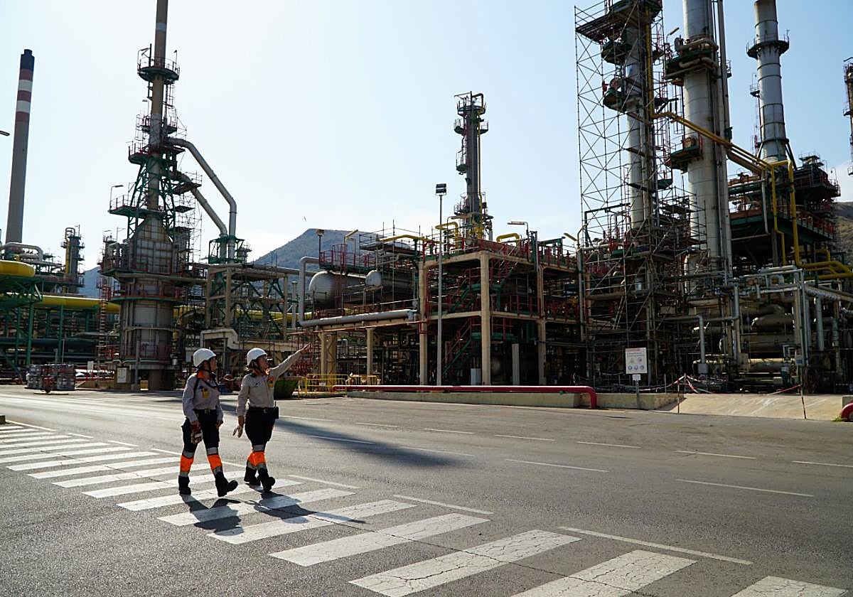 Dos trabajadores de la refinería de Escombreras pasean junto a las instalaciones de Repsol en Cartagena.