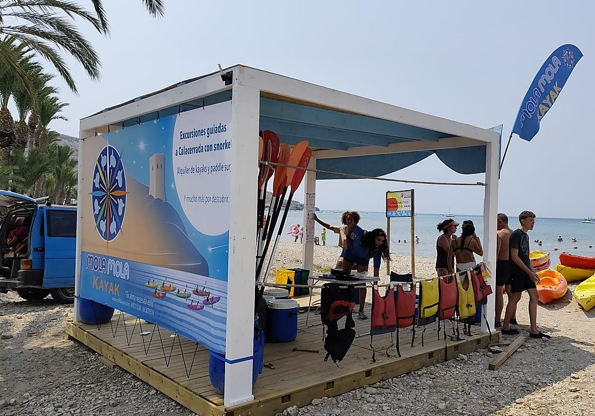 Clientes visitan la caseta de Mola Mola Kayak en la playa del Cuartel, en La Azohía.