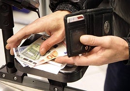 Una persona paga con dinero en efectivo.