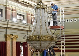 Un operario estudia la lámpara antes de proceder a su limpieza.