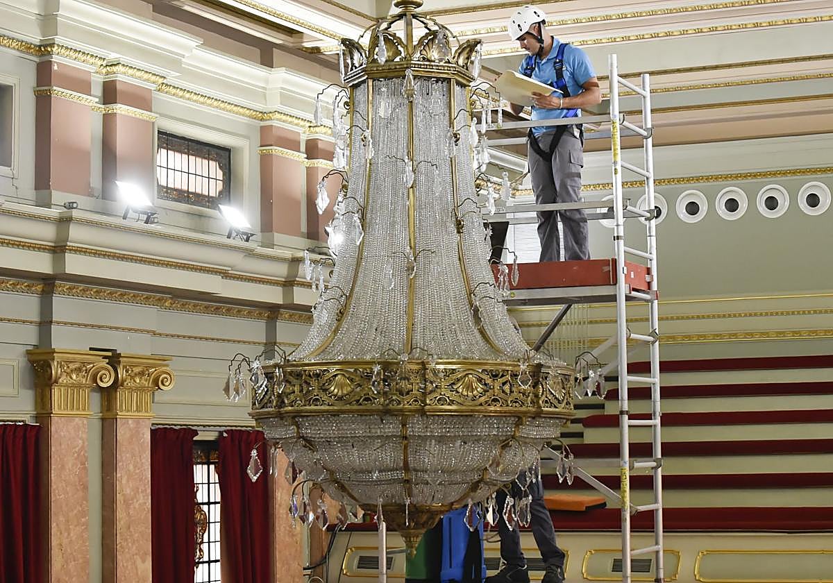 Un operario estudia la lámpara antes de proceder a su limpieza.