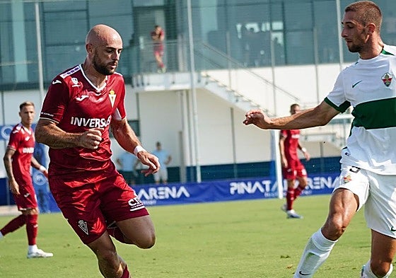 Ekain, atacante del Real Murcia, conduce la pelota ante un defensa del Ilicitano.